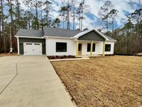 Charming one-story home boasting dark-trim windows, a two-car garage, and lovely yellow-toned support columns at 5374 Hampton Rd., Conway, SC 29527