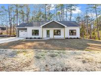 Charming single-story home featuring white siding, gray accents, and a well-maintained front yard surrounded by tall pine trees at 5374 Hampton Rd., Conway, SC 29527