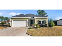 Charming single-story home with a well-manicured lawn, attached garage, and inviting landscaping at 685 Tidal Point Ln., Myrtle Beach, SC 29579