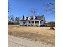 Charming home featuring a covered front porch, white siding, dormers, and a brick chimney at 721 Old Buck Creek Rd., Longs, SC 29568