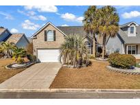 Charming brick home featuring an attached garage and lush, mature landscaping, including palm trees at 7228 Guinevere Circle, Myrtle Beach, SC 29588