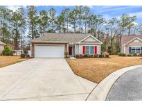 Charming single-story home featuring a two-car garage, red shutters, and well-maintained landscaping at 817 Riverwood Ct., Little River, SC 29566