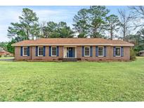 Charming brick home features a large front yard, blue shutters and a beautiful lawn at 83 Pond St., Georgetown, SC 29440