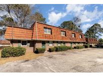 Brick exterior with unique wood roof, green doors, and lots of plants in front of this multi Gathering townhome at 1025 Carolina Rd. # Cc2, Conway, SC 29526