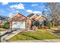 Charming brick home showcasing a well-manicured lawn and an attached two-car garage at 118 Ellington Ln., Pawleys Island, SC 29585