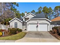 Charming home with a well-maintained lawn, two-car garage, and beautiful architectural details at 1239 Trisail Ln, North Myrtle Beach, SC 29582
