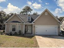Charming single-story home featuring a two-car garage, manicured lawn, and inviting front entrance at 13 Daniel Morrall Ln., Georgetown, SC 29440