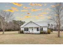 Charming single-story home with a metal roof, covered front porch, and well-manicured lawn at 1771 Southern Crest Dr., Loris, SC 29569