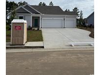New construction of a single Gathering home with a three car garage and freshly poured driveway at 183 Glengrove Lane, Murrells Inlet, SC 29576