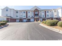 Condominium exterior showcasing the building's facade, garages and manicured landscaping at 2241 Waterview Dr. # 227, North Myrtle Beach, SC 29582