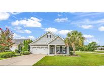 Charming one-story home featuring a well-maintained lawn, attached two-car garage, and inviting front porch at 3600 White Wing Circle, Myrtle Beach, SC 29579