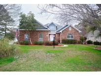 Charming brick home featuring manicured lawn and inviting landscaping at 4228 Highway 1008, Little River, SC 29566