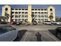 View of parking lot and building, featuring balconies and light yellow accents at 4519 N Plantation Harbour Dr. # X - 19, Little River, SC 29566