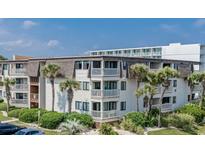 Beautiful exterior of a condo building with palm trees and well-maintained landscaping at 5601 N Ocean Blvd. # E-111, Myrtle Beach, SC 29577