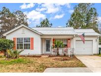 Charming single-story home boasts a metal roof, a manicured lawn, and a one-car garage at 9514 Leeds Circle, Myrtle Beach, SC 29588