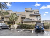 Inviting multi-story condo building with beige siding, well-manicured landscaping, and ample parking at 9551 Edgerton Dr. # C-6, Myrtle Beach, SC 29572