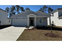 Charming single-story home boasts a well-manicured lawn, attached garage, and inviting front entrance at 981 Laconic Dr., Myrtle Beach, SC 29588