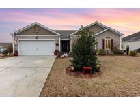 Charming single-story home featuring manicured landscaping, an attached garage, and inviting curb appeal at 1052 Mccall Loop, Conway, SC 29526