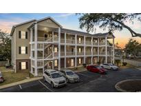 Beige three-story condo building with covered staircases and parking at 1058 Sea Mountain Hwy. # 14-302, North Myrtle Beach, SC 29582
