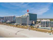 Stunning aerial view of a beachfront resort with a red pin, highlighting its prime location by the sandy beach at 205 74Th Ave. N # 1508, Myrtle Beach, SC 29572