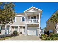 Charming two-story home with a front-facing balcony, white trim, and an attached garage at 2204 Tidewatch Way # 2204, North Myrtle Beach, SC 29582