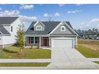 Charming single-Gathering home with a two-car garage, beautiful landscaping, and a welcoming front porch at 2416 Campton Loop, Conway, SC 29527