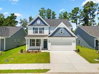 Beautiful two-story home with blue shutters, gabled roof, and well-manicured lawn at 2420 Campton Loop, Conway, SC 29527