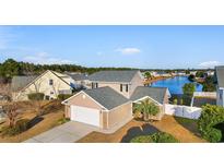 Beautiful home with a well-manicured lawn, attached garage, and scenic water view at 4387 Heartwood Ln., Myrtle Beach, SC 29579