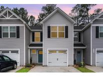 Inviting townhouse featuring neutral siding, black shutters, single car garage, and well-manicured lawn at 616 C Montenegro Way # C, Myrtle Beach, SC 29579