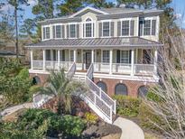 Charming two-story home boasts a welcoming porch, mature landscaping, and unique architectural details at 80 Stonington Dr., Murrells Inlet, SC 29576
