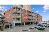 Beach condo building featuring multiple units with balconies overlooking the ocean and parking at 900 N Waccamaw Dr. # 303, Murrells Inlet, SC 29576
