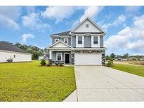 Charming two-story home with blue siding, stone accents, and a spacious front yard at 1064 Jase Dr., Longs, SC 29568