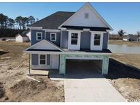 New construction two-story home with light gray siding and a spacious two-car garage at 1064 Jase Dr., Longs, SC 29568