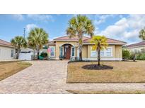 Charming single-story home featuring a terracotta-tiled roof, palm trees, and a brick-paved driveway at 140 Northside Dr., Little River, SC 29566