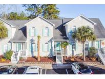 Charming two-story condo with a white brick facade and light blue shutters, exuding curb appeal at 1456 Baldwin Ct. # 1456, Little River, SC 29566