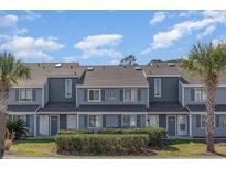 Inviting townhome featuring a neatly landscaped yard and a charming, symmetrical facade with gray tones at 1881 Colony Dr. # 8-S, Surfside Beach, SC 29575