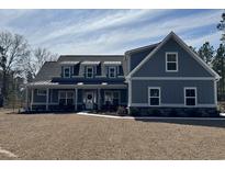 Charming two-story home with a welcoming porch, dormer windows, and manicured lawn at 2076 Fawn Run, Conway, SC 29526