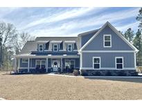 Charming blue two-story home featuring a welcoming front porch and neatly maintained landscaping at 2076 Fawn Run, Conway, SC 29526