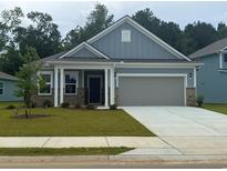 Charming single-Gathering home with an attached two-car garage and a well-manicured lawn at 2534 Watershed Way, Longs, SC 29568