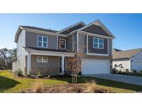 Charming two-story home featuring stone accents, a two-car garage, and neutral-colored siding at 354 Glacier Way, Conway, SC 29526