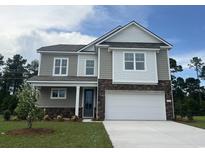 Charming two-story home featuring a mix of gray siding, stone accents, and a large two-car garage at 354 Glacier Way, Conway, SC 29526