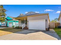 Charming home with a well-manicured front yard and an attached two-car garage at 3816 James Pl., Little River, SC 29566