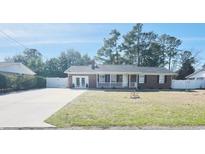 Charming single-story brick home featuring a cozy front porch and well-maintained front yard at 4048 Sandtrap Ave., Little River, SC 29566