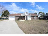 Charming brick home features an attached garage and a well-manicured front lawn at 4339 Dew N. Ct., Myrtle Beach, SC 29579