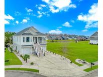 Charming two-story home with a well-maintained front yard and an inviting staircase leading to the front porch at 518 Harbour View Dr., Myrtle Beach, SC 29579