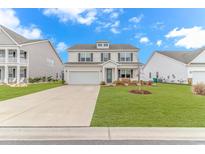 Charming two-story home features a manicured lawn and a large driveway leading to an attached two-car garage at 560 Pier Ct., Longs, SC 29568