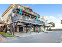 Coastal home with a large, covered outdoor space, elevated design and blue umbrellas on the deck at 6001-0917 S Ocean Blvd., Myrtle Beach, SC 29575