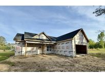 New construction home with a two-car garage and a spacious front yard, ready for landscaping at 6049 Hodges Rd., Conway, SC 29527