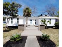 Charming white home with a modern boardwalk style front entrance and blue front door at 616 36Th Ave. S, North Myrtle Beach, SC 29582