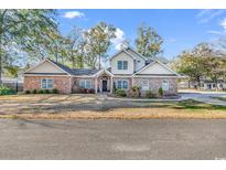 Charming brick two-story home with manicured front yard and inviting entrance at 710 Cedar Dr. S, Surfside Beach, SC 29575